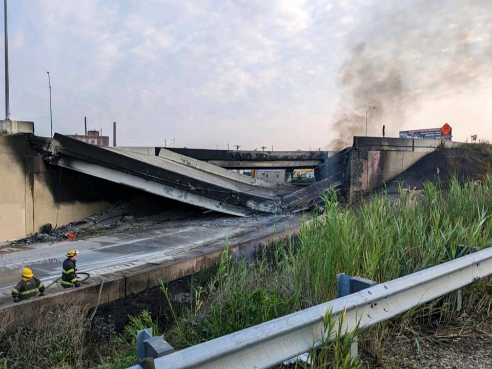 Firefighters stand near the collapsed part of I-95.