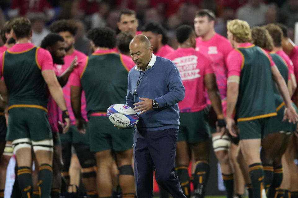 Australia's head coach Eddie Jones holds a rugby ball during the warm-up before the Rugby World Cup Pool C match between Wales and Australia at the OL Stadium in Lyon, France, Sunday, Sept. 24, 2023. (AP Photo/Christophe Ena)