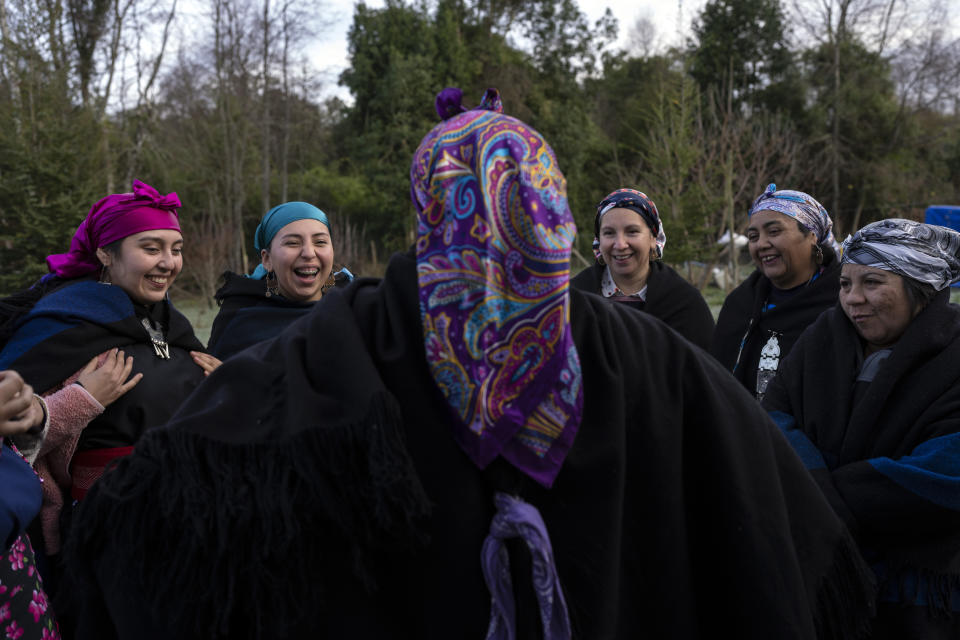 Millaray Huichalaf, center, a Mapuche machi, or healer and spiritual guide, celebrates We Tripantu, the Mapuche new year, with Huenchupan family members in Lof Soyinka, Los Rios, southern Chile, on Wednesday, June 22, 2022. Coinciding with the winter solstice in the Southern Hemisphere, the late June festivities mark the “new rising of the sun" and signify "the change and renovation of life, in all senses," according to Huichalaf's sister Amanda. (AP Photo/Rodrigo Abd)