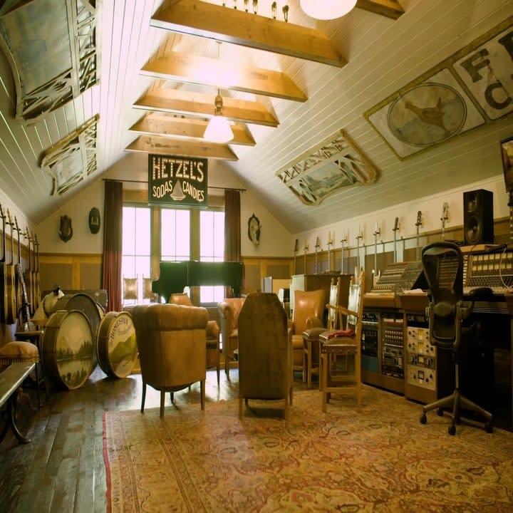 The barn has a recording studio with guitars on the wall and a piano
