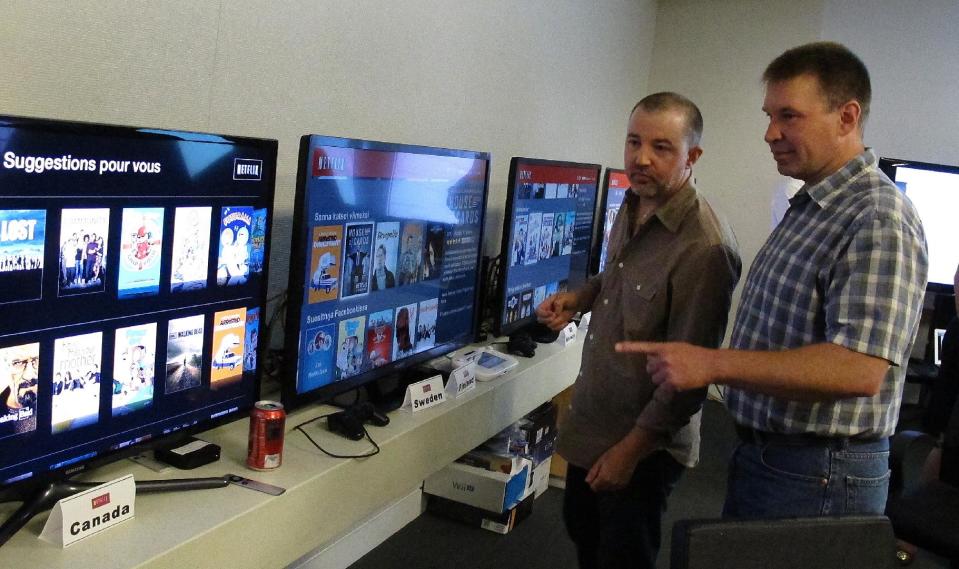 In this photo taken Wednesday, July 10, 2013, Chris Jaffee, Netflix VP of Product Innovation, left, and Bob Heldt, Director of Engineering, look over video displays as they await the debut of "Orange is the new black" in Los Gatos, Calif. (AP Photo/Michael Liedtke)