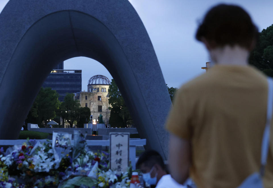A visitor pays in front of the cenotaph dedicated to the victims of the atomic bombing at the Hiroshima Peace Memorial Park in Hiroshima, western Japan Saturday, Aug. 6, 2022. Hiroshima on Saturday marked the 77th anniversary of the world's first atomic bombing of the city. (Kenzaburo Fukuhara/Kyodo News via AP)