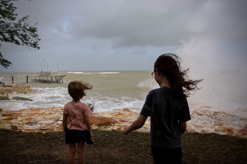Nyah and Thea watch as the top end storms roll in across Nightcliff beach and Jetty in Darwin. Neve Brissenden/AAP/dpa
