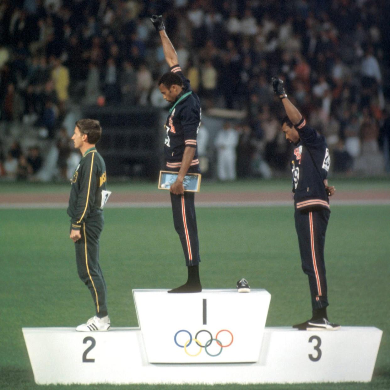 Tommy Smith and John Carlos stand on the Olympic winners platform with fists raised during the national anthem