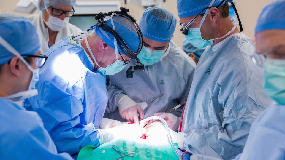Dr. Michael Hinni, center left, Dr. Payam Entezami, center, and Dr. David Lott, center right, operate on transplant patient Marty Kedian in Phoenix in February. - Mayo Clinic via AP