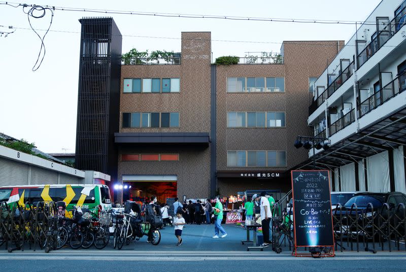 People gather as they attend a drink, chats and music live event hosted by a factory in Higashiosaka