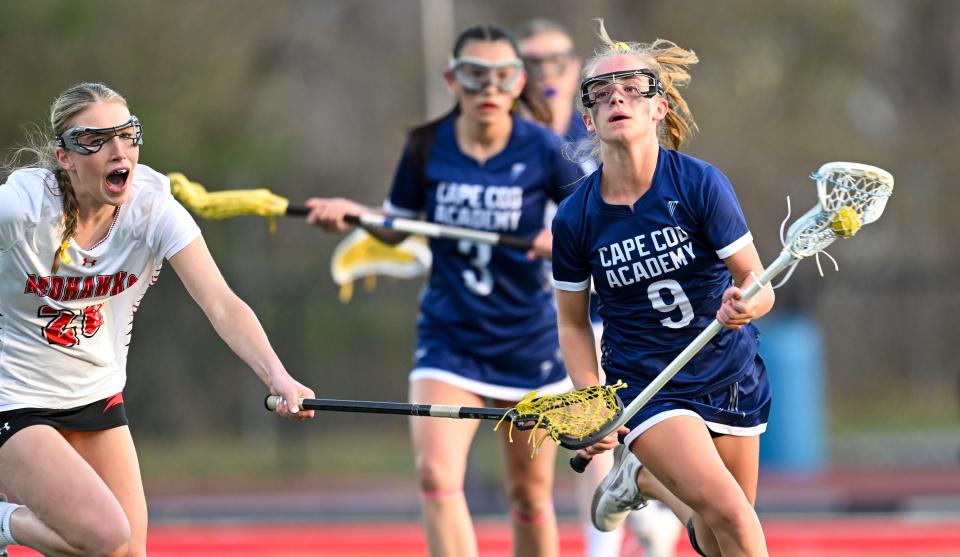 Quinn Powers of Cape Cod Academy moves past Caroline Curley of Barnstable.