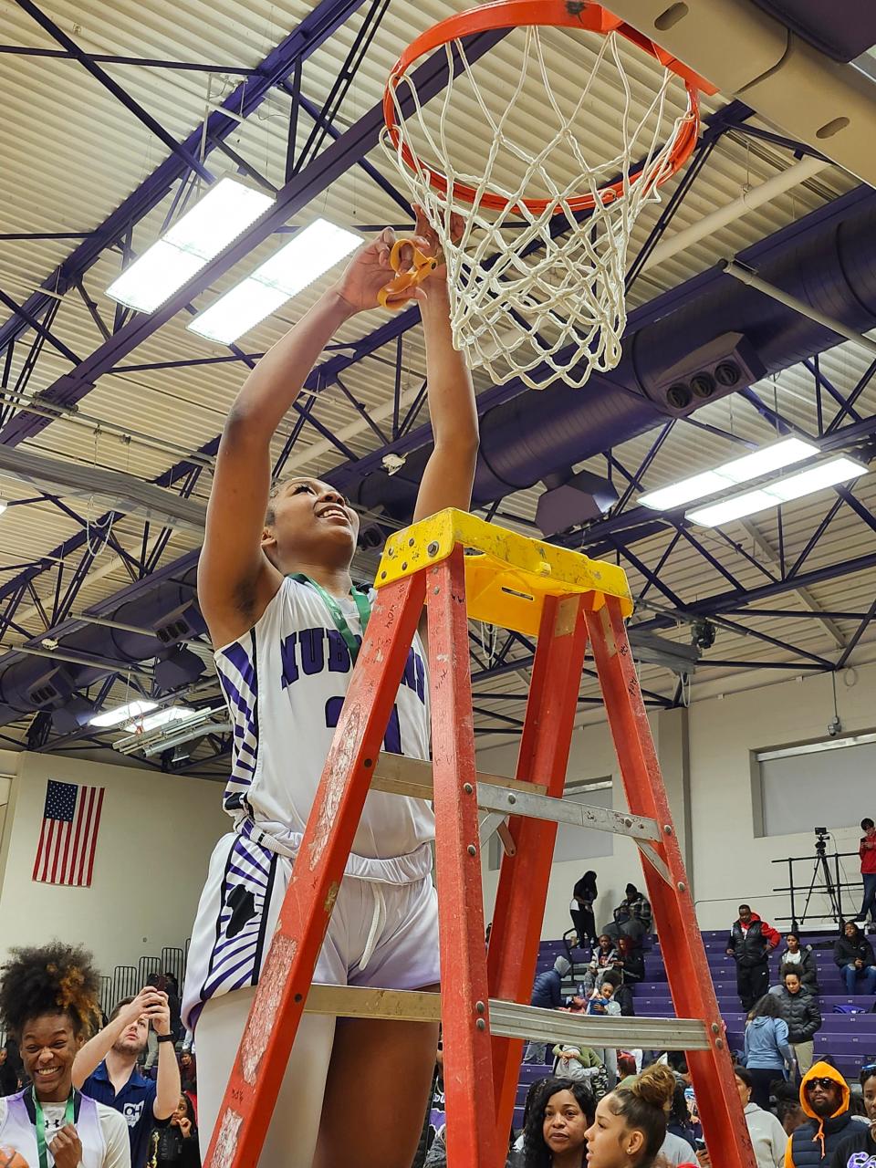 Africentric senior Natiah Nelson cuts down the net in celebration after a 52-29 win over Centerburg in a Division III district final Thursday night at Capital.