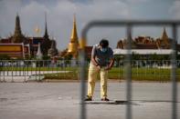 A man takes a picture at the place where a plaque placed by Thai pro-democracy protesters near the Grand Palace in Bangkok that declared that Thailand belongs to the people and not the king, after the plaque was removed according to police, in Bangkok