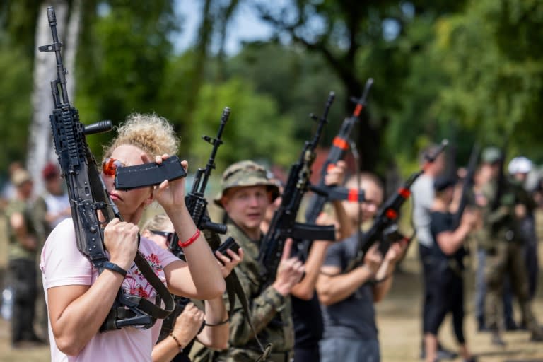 Des civils s'entraînent au maniement des armes lors d'une formation militaire dans le cadre d'un programme d'été de l'armée polonaise sur la base militaire de Tomaszów Mazowiecki, le 6 juillet 2024 (Wojtek Radwanski)