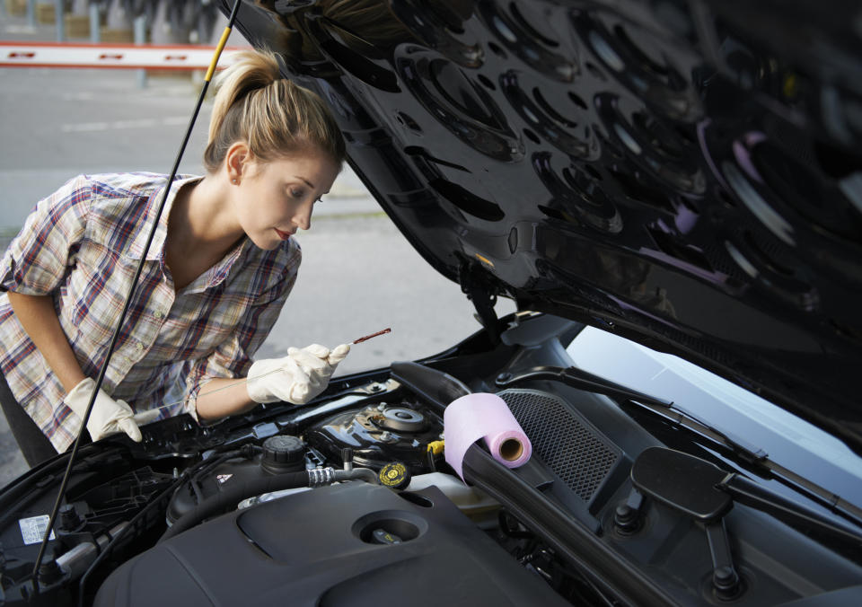 Using a dipstick to check a car's oil level