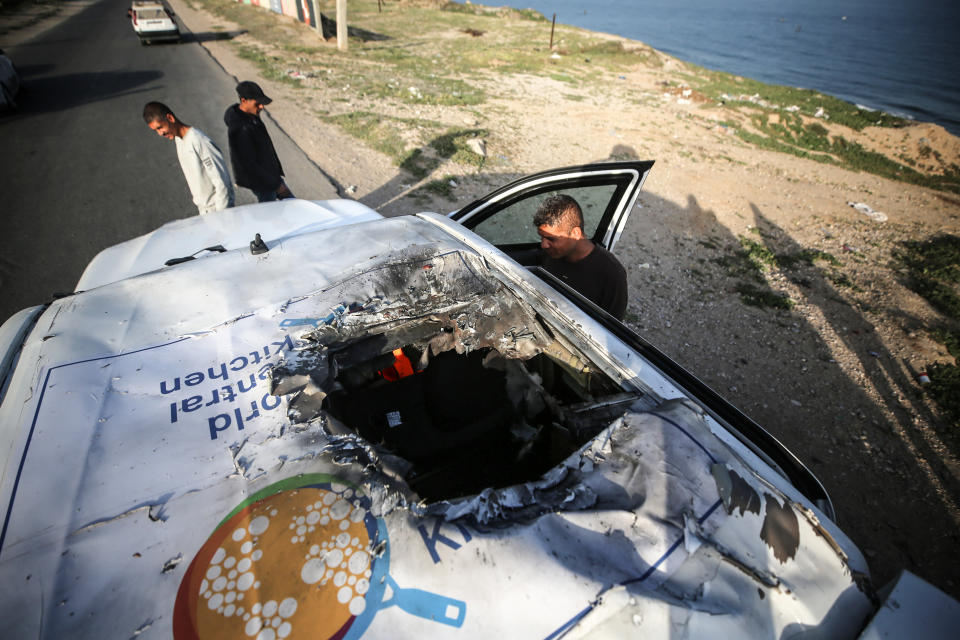 Palestinians are standing next to a vehicle in Deir Al-Balah, in the central Gaza Strip, on April 2, 2024, where employees from the World Central Kitchen (WCK), including foreigners, were killed in an Israeli airstrike, according to the NGO. The Israeli military is stating that it is conducting a thorough review at the highest levels to understand the circumstances of this ''tragic'' incident, amid the ongoing conflict between Israel and Hamas. (Photo by Majdi Fathi/NurPhoto via Getty Images)