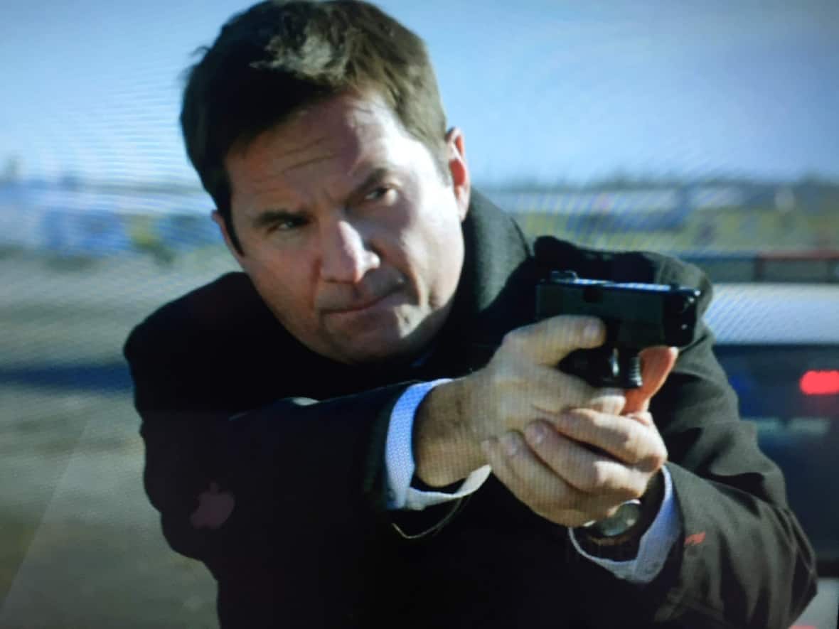 Peter Michael Dillon holds a fake gun in the 2015 TV movie First Response. Like many in Ottawa's film community, Dillon was shaken by the death of cinematographer Halyna Hutchins on the set of the Alec Baldwin film Rust. (Submitted by Peter Michael Dillon - image credit)