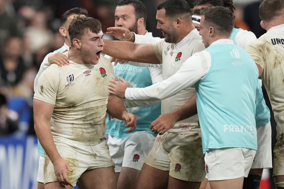 England's Theo Dan, left, is congratulated by teammates after scoring a try during the Rugby World Cup third place match between England and Argentina at the Stade de France in Saint-Denis, outside Paris, Friday, Oct. 27, 2023. (AP Photo/Themba Hadebe)