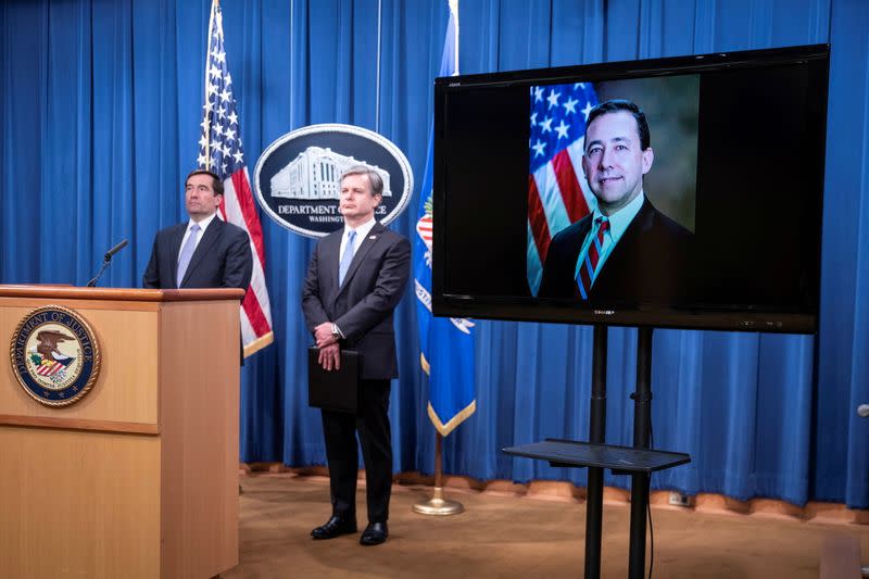 Assistant Attorney General for National Security John C. Demers and FBI Director Christopher Wray attend a virtual news conference at the Department of Justice in Washington