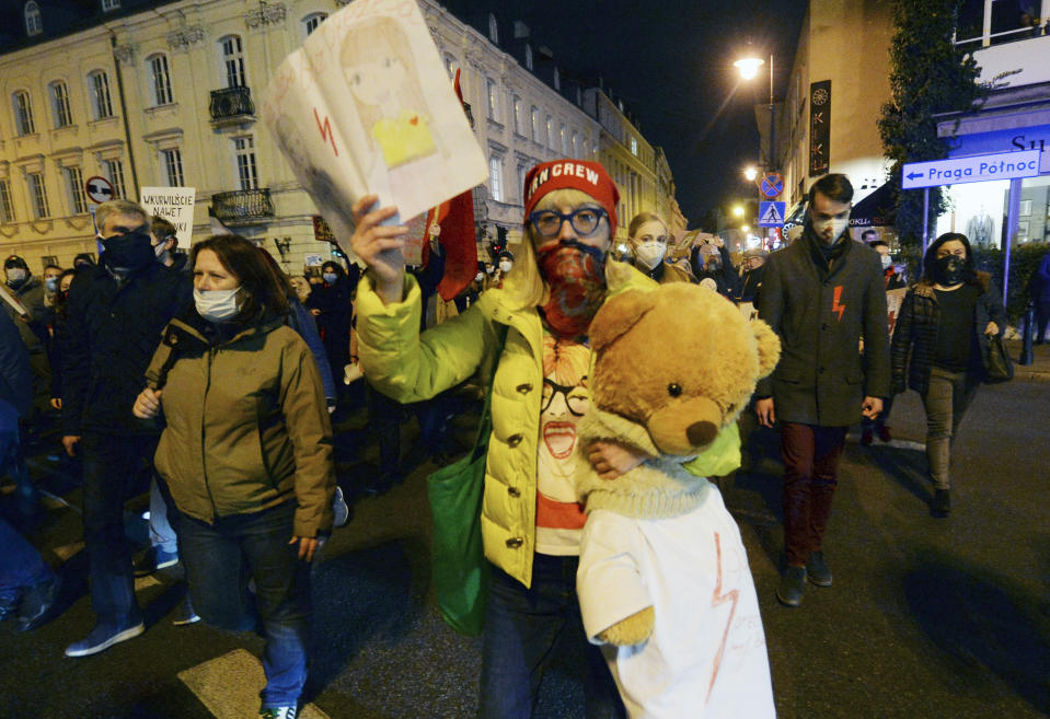 Young people take part in a protest against the conservative government, on the eighth straight day of angry demonstrations that were triggered by a recent tightening of the abortion law, in the Old Town, in Warsaw, Poland, Friday, Oct. 30, 2020.(AP Photo/Czarek Sokolowski)