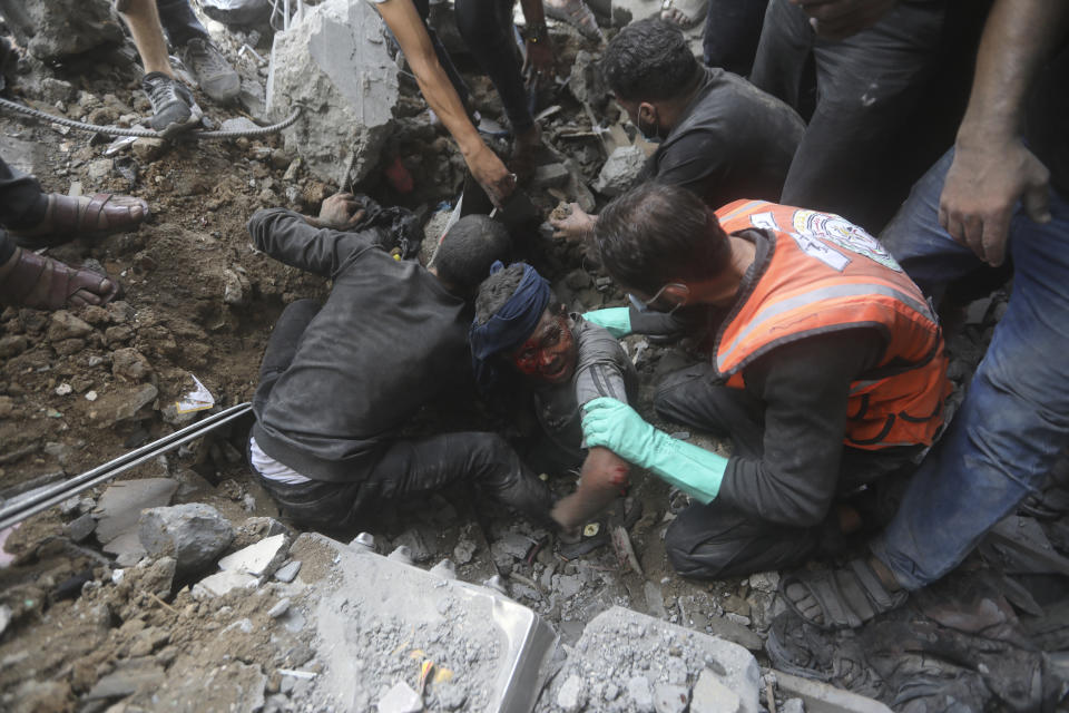 Palestinian rescuers try to pull an injured boy out of the rubble of a destroyed building following an Israeli airstrike in Bureij refugee camp, Gaza Strip, Thursday, Nov. 2, 2023. (AP Photo/Mohammed Dahman)
