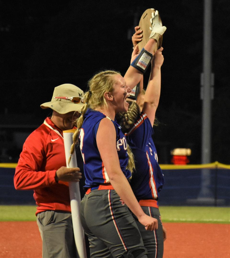 Logan Cookinham (foreground) and senior classmates Sarah Zuchowski and Shelbi Hagues hoist the regional championship plaque they earned with Saturday's victory over Edwards-Knox at Carrier Park in Syracuse.