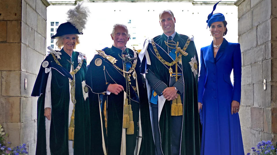 Members of the British royal family standing together in royal regalia and smiling
