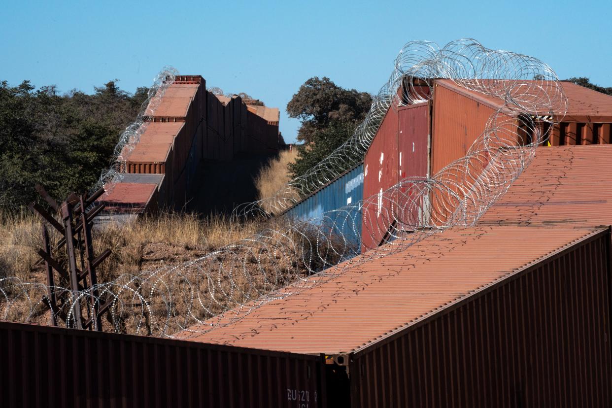 Doubled-stacked shipping containers topped with razor wire are replacing the Normandy vehicle barriers (left) on the U.S./Mexico border on Nov. 18, 2022, southwest of Sierra Vista, Arizona.