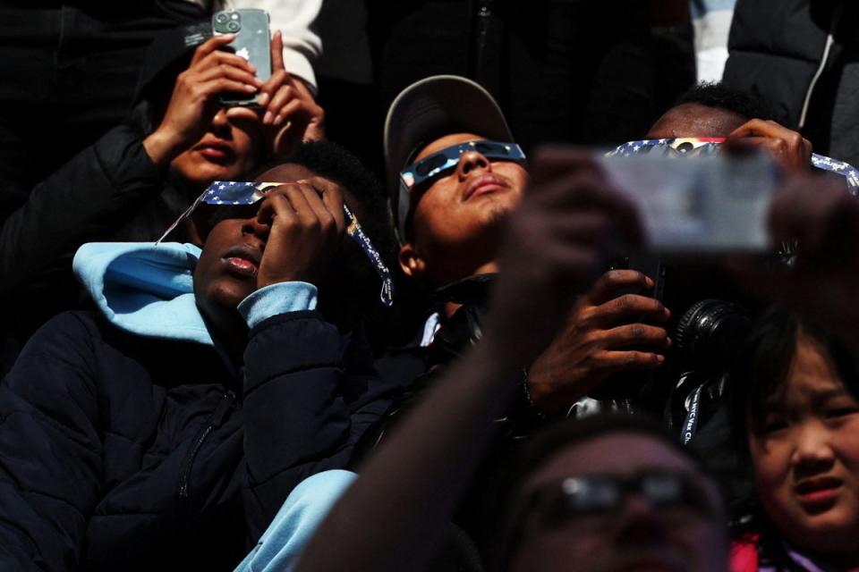 People assemble to view a partial solar eclipse, where the moon will partially blot out the sun, at Times Square in New York City.<span class="copyright">Shannon Stapleton—Reuters</span>