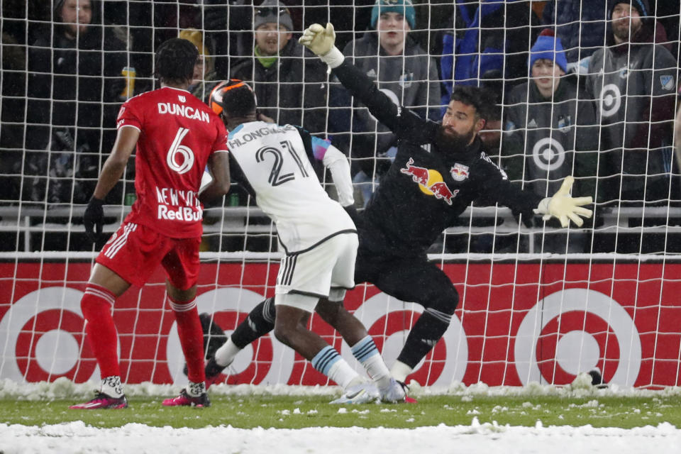 CORRECTS TO ST. PAUL, MINN., NOT MINNEAPOLIS - Minnesota United forward Bongokuhle Hlongwane (21) gathers a rebound off New York Red Bulls goalkeeper Carlos Miguel Coronel, right, and scores a goal in the first half of an MLS soccer game Saturday, March 11, 2023, in St. Paul, Minn. (AP Photo/Bruce Kluckhohn)