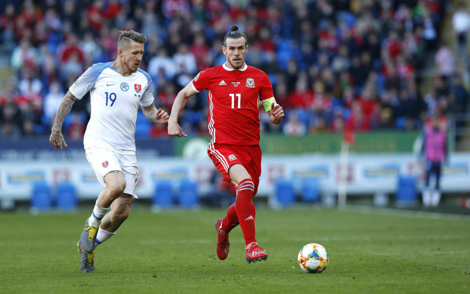 Slovakia's Juraj Kucka, left, and Wales' Gareth Bale battle for the ball during the Euro 2020 qualifying, Group E soccer match at the Cardiff City Stadium, Wales, Sunday March 24, 2019. (Darren Staples/PA via AP)