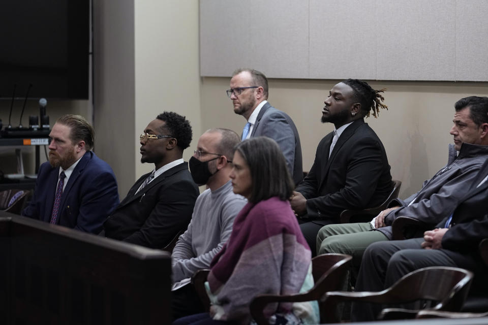Rakim Sharkey, second from left, and Elijah Teel, fifth from left, who police identified as traffickers, and others listen as Irma Reyes makes a statement Judge Velia Meza's court, Monday, Jan. 23, 2023, in San Antonio. Reyes' daughter was one of two teens who men were accused of keeping at a San Antonio motel where other men paid to have sex with them in 2017. Their cases have seen years of delay, a parade of prosecutors, an aborted trial and, ultimately, a stark retreat by the government with the offer of a plea deal. (AP Photo/Eric Gay)