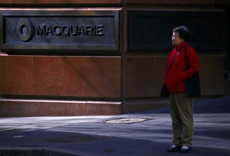 A pedestrian stands near the logo of Australia's biggest investment bank Macquarie Group Ltd which adorns a wall on the outside of their Sydney office headquarters in central Sydney, Australia, July 18, 2017. REUTERS/David Gray