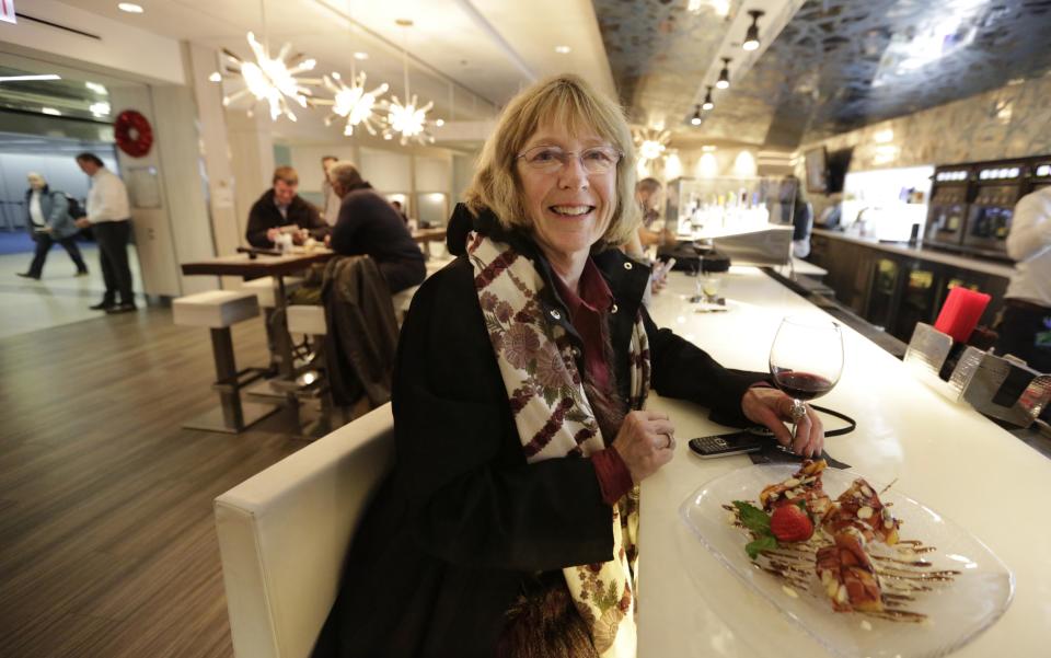 In this photo taken Tuesday, Dec. 18, 2012, at O'Hare International Airport in Chicago, Marty Rapp relaxes at at ICE Bar in Terminal 3 between flights. Getting stranded at an airport once meant camping on the floor and enduring hours of boredom in a kind of travel purgatory with nothing to eat but fast food. Tough economic times are helping drive airports to make amends and transform terminals with a bit of bliss: spas, yoga studios, luxury shopping and restaurant menus crafted by celebrity chefs. (AP Photo/M. Spencer Green)