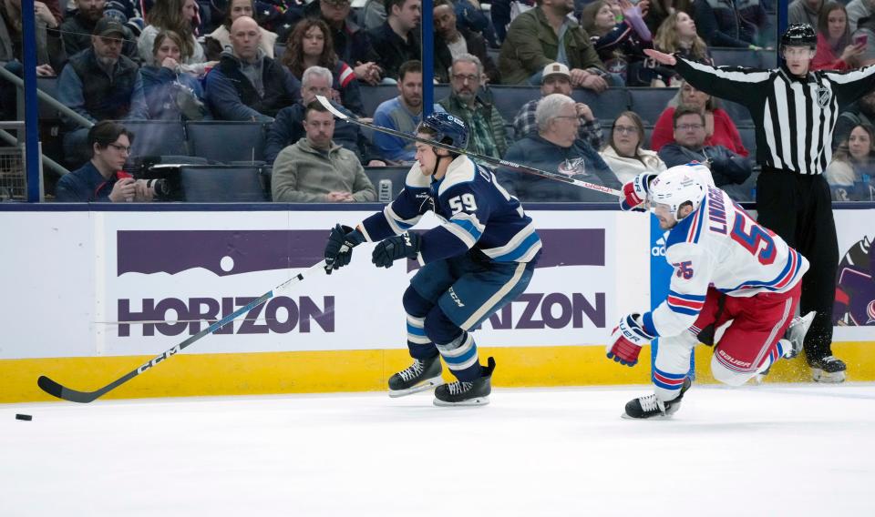 Feb. 25, 2024; Columbus, Ohio, USA; 
Columbus Blue Jackets right wing Yegor Chinakhov (59) takes a stick to the head from New York Rangers defenseman Ryan Lindgren (55) during the third period of an NHL game at Nationwide Arena on Sunday.