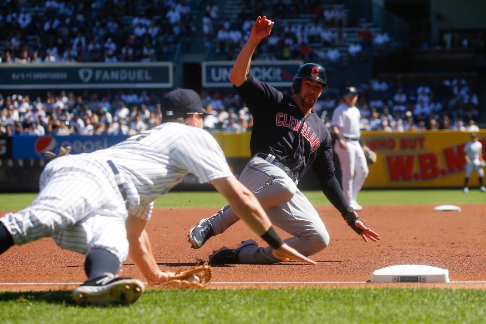 Cleveland Indians' Bradley Zimmer, right, dives safely into third base as New York Yankees' DJ LeMahieu tries to tag him out in the first inning of a baseball game, Sunday, Sept. 19, 2021, in New York. (AP Photo/Eduardo Munoz Alvarez)