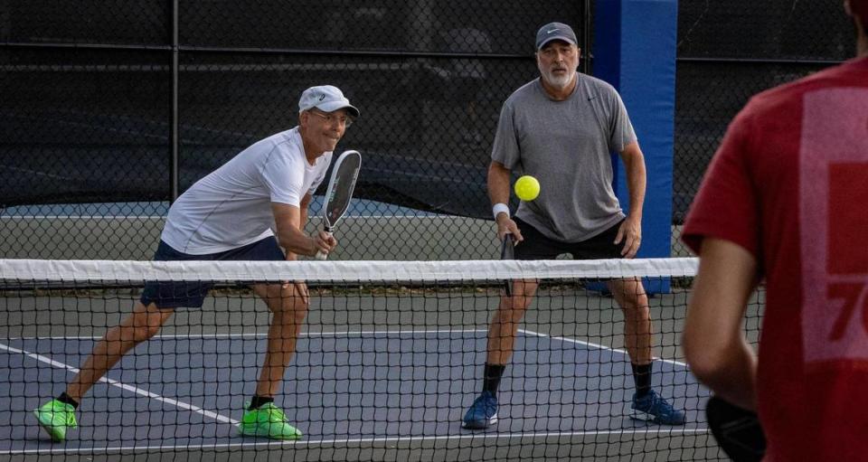 Michael Gallinar, left, and Manny Sires, right, in action during a pickleball match at the pickleball courts in Tropical Park.