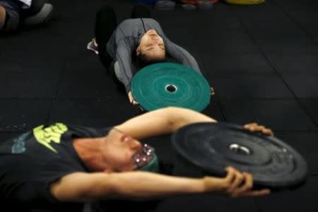 Kim Jin-ah (top), 31, exercises during a crossfit class at a gym in Seoul, September 11, 2015.REUTERS/Kim Hong-Ji