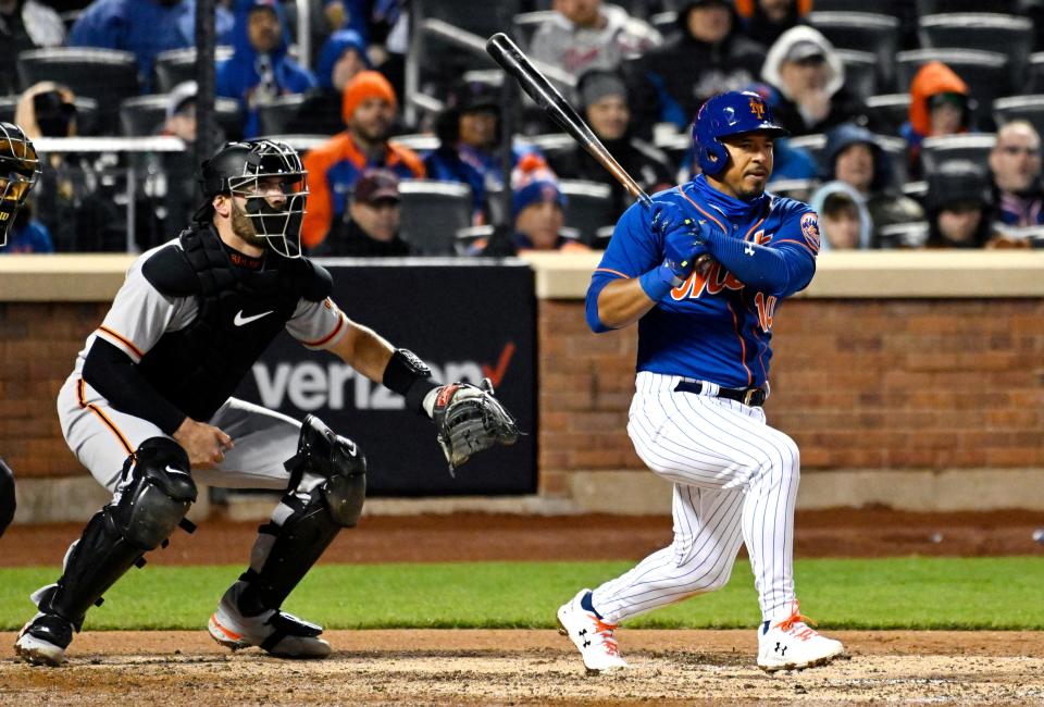 New York Mets' Eduardo Escobar hits a two-RBI double as San Francisco Giants catcher Curt Casali, left, looks on during the third inning of the second game of a baseball double-header Tuesday, April 19, 2022, in New York.