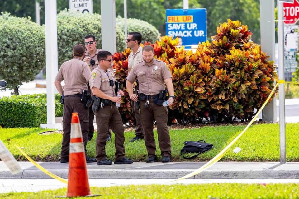 Miami-Dade Police officers and detectives gather outside the Shell gas station near the crime-scene after another Miami-Dade mass shooting and a possibly connected car crash killed three people and sent five or six others to the hospital with gunshot wounds, around Grand Salon Reception Hall at Southwest 104th Street and 109th Court in the Kendall neighborhood of Miami, Florida, on Sunday, June 6, 2021.