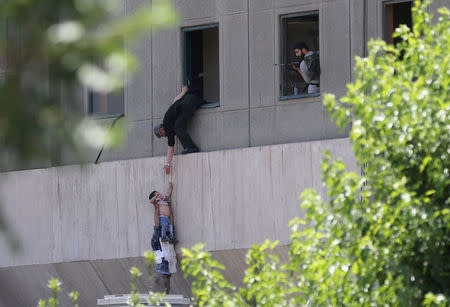 FILE PHOTO: A boy is evacuated during an attack on the Iranian parliament in central Tehran, Iran June 7, 2017. Omid Vahabzadeh/TIMA via REUTERS/File Photo via REUTERS