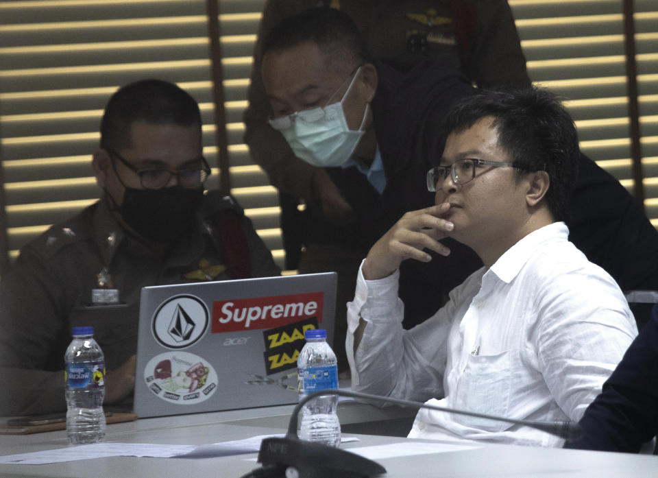 Pro-democracy activist and human rights lawyer Arnon Nampha, right, sits at a police station, Friday, Aug, 7, 2020, in Bangkok, Thailand. The government cracked down on Friday with the arrests of some high profile members of the pro-democracy movement. Among them was Arnon, who was arrested on charges of sedition and defying an emergency decree the government instituted months ago to try to control the spread of the coronavirus. (AP Photo/Sakchai Lalit)