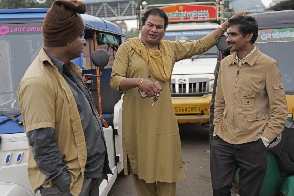 Preethi, a 38-year-old transgender woman who uses only her first name, chats with fellow auto rickshaw drivers as she waits for customers to ferry in her electric auto rickshaw in Bengaluru, India, Wednesday, July 12, 2023. Electric vehicles sales are skyrocketing, and experts say it’s crucial that everyone benefits from these big moves toward clean energy. (AP Photo/Aijaz Rahi)