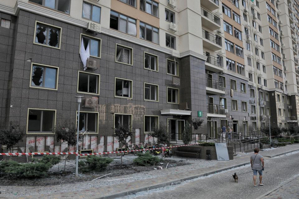 A local resident walks with a dog next to an apartment building damaged during Russian missile and drone strikes, amid Russia's attack on Ukraine, near Odesa (REUTERS)