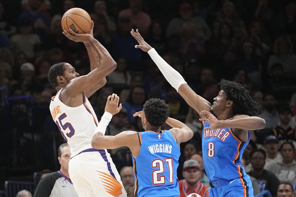 Phoenix Suns forward Kevin Durant (35) shoots over Oklahoma City Thunder guard Aaron Wiggins (21) and forward Jalen Williams (8) in the first half of an NBA basketball game Sunday, April 2, 2023, in Oklahoma City. (AP Photo/Sue Ogrocki)