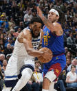 Minnesota Timberwolves center Karl-Anthony Towns, left, drives past Denver Nuggets forward Aaron Gordon, right, in the second half of Game 1 of an NBA basketball second-round playoff series Saturday, May 4, 2024, in Denver. (AP Photo/David Zalubowski)