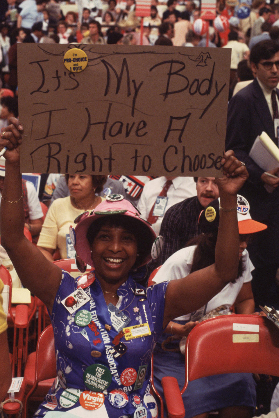 A woman holding up a sign reading "It's My Body And I Have A Right To Choose"