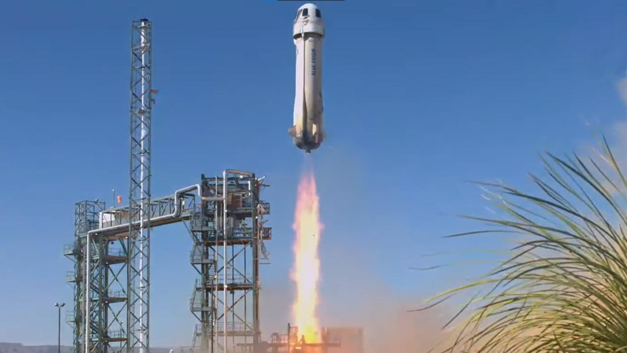  A white rocket lifts off from the Texas desert under a blue sky. 