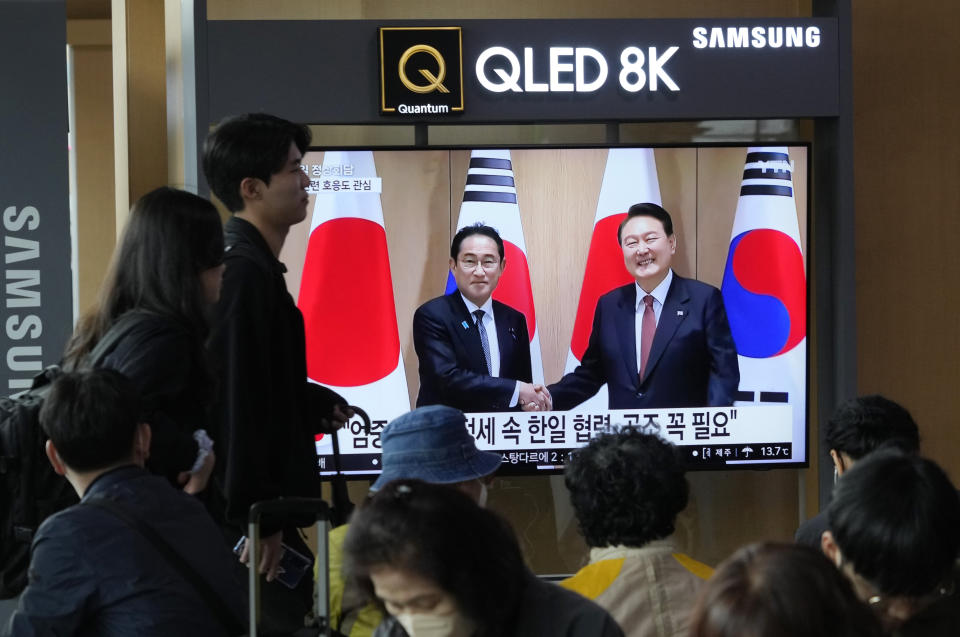 People pass by a TV screen showing South Korean President Yoon Suk Yeol meeting with Japanese Prime Minister Fumio Kishida, left, during a news program at the Seoul Railway Station in Seoul, South Korea, Sunday, May 7, 2023. The leaders of South Korea and Japan met Sunday for their second summit in less than two months, as they push to mend long-running historical grievances and boost ties in the face of North Korea's nuclear program and other regional challenges. (AP Photo/Ahn Young-joon)