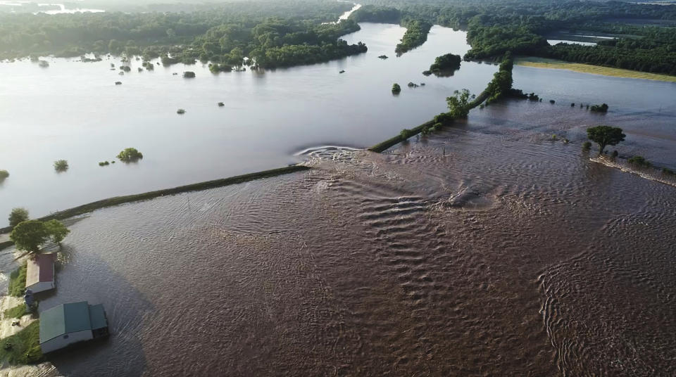 In this aerial image provided by Yell County Sheriff's Department water rushes through the levee along the Arkansas River in Dardanelle, Ark., on Friday, May 31, 2019. Officials say the levee breached early Friday at Dardanelle, about 60 miles northwest of Little Rock. (Yell County Sheriff's Department via AP)