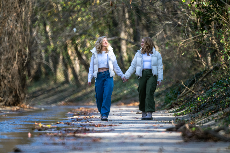 two women walking on a path in the woods