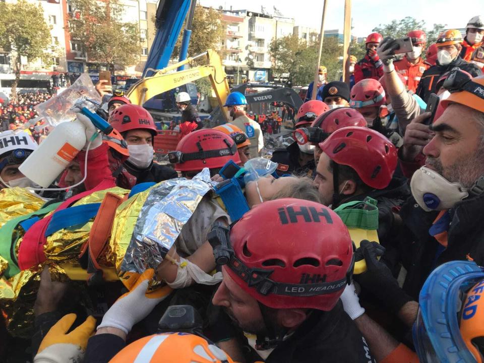 In this photo provided by Turkey's IHH humanitarian aid group, Ayda Gezgin is carried by members of rescue services and medics after she was taken out of the rubble of her collapsed building, in Izmir, Turkey, Tuesday, Nov. 3, 2020. Rescuers in the Turkish coastal city pulled Gezgin out alive from the rubble, some four days (91 hours) after a strong earthquake hit Turkey and Greece. The girl was taken into an ambulance, wrapped in a thermal blanket, amid the sounds of cheers and applause from rescue workers. (IHH via AP)