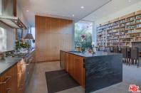 <p>The open-concept first floor also connects to a kitchen with sculpted soapstone countertops, a centre island, marble backsplash and Scandinavian-style custom wood cabinetry. (Zillow) </p>
