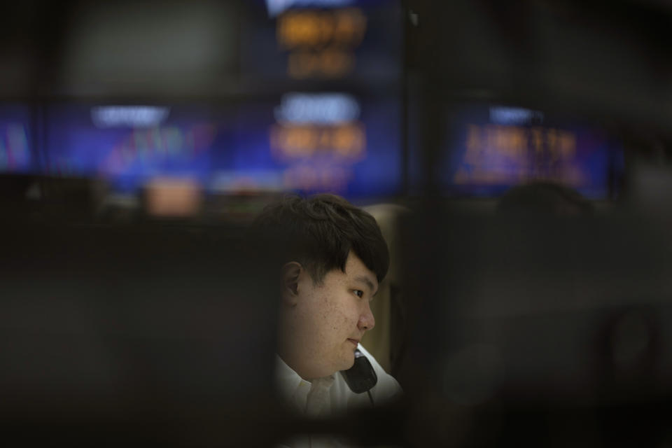 A currency trader talks on the phone at a foreign exchange dealing room in Seoul, South Korea, Tuesday, April 11, 2023. Stocks were mostly higher in Asia on Tuesday after a mixed session on Wall Street dominated by speculation the Federal Reserve may tap the brakes again on financial markets and the economy by raising interest rates. (AP Photo/Lee Jin-man)